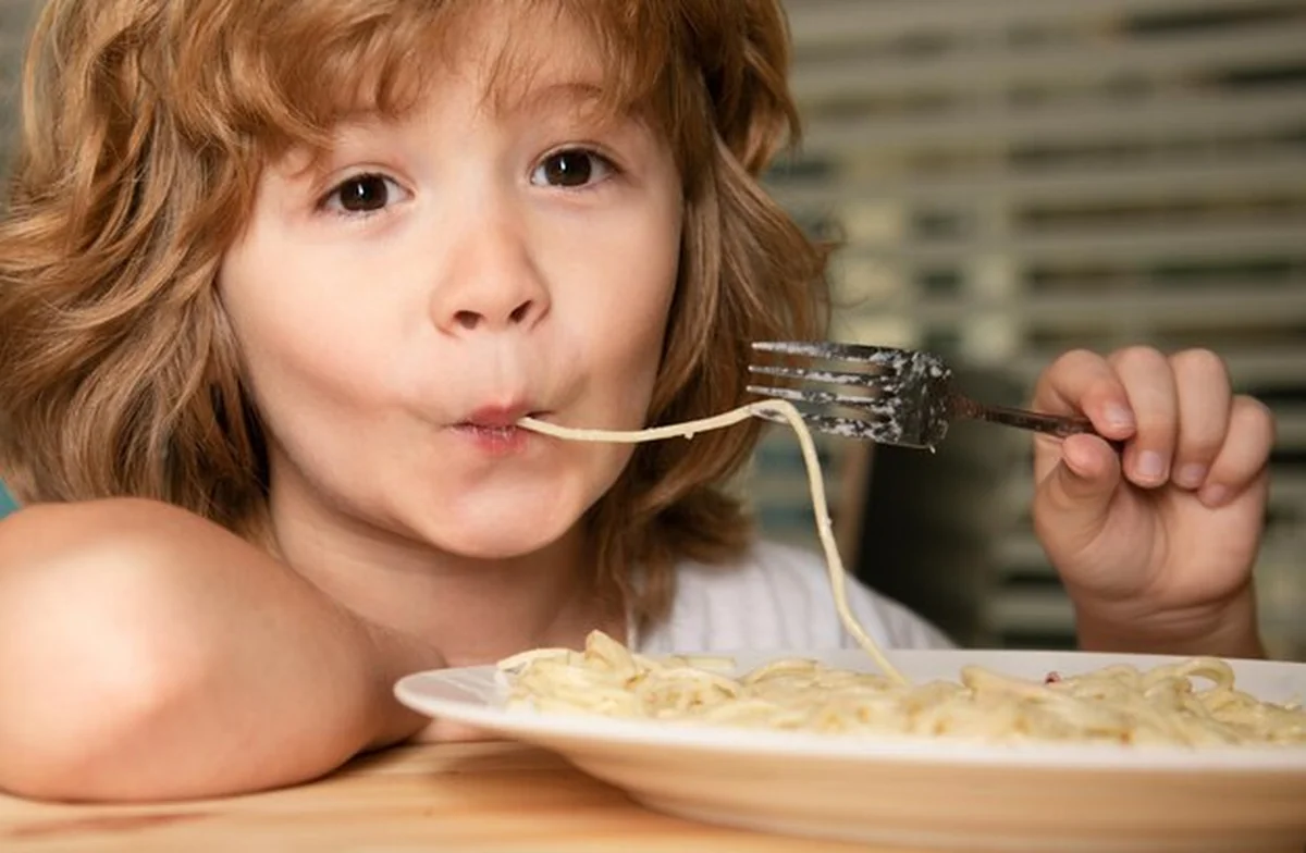 Dzieci jedzące makaron i spaghetti z bliska urocze zabawne dziecko