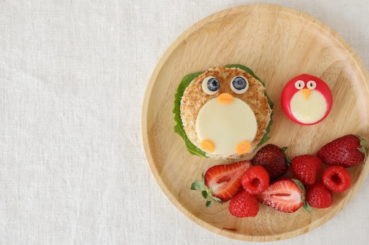 Pingwin z owocami na talerzu dla dzieci